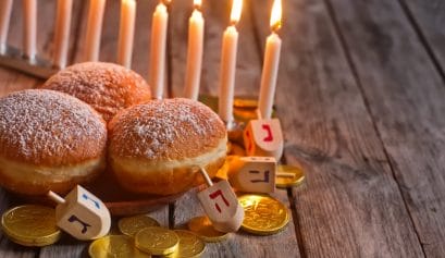 Jewish holiday hannukah recipes can be served alongside symbols - menorah, doughnuts, chockolate coins and wooden dreidels.