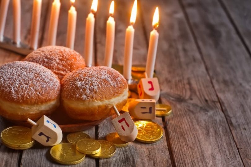 Jewish holiday hannukah recipes can be served alongside symbols - menorah, doughnuts, chockolate coins and wooden dreidels. 