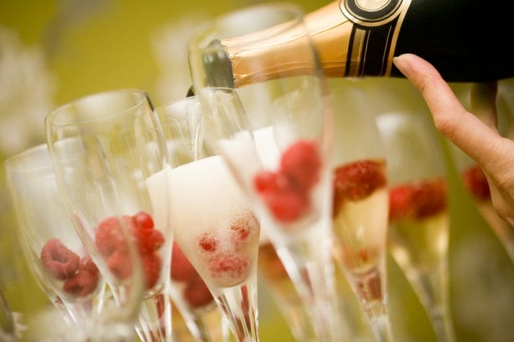 serving champagne for new year's eve with raspberries